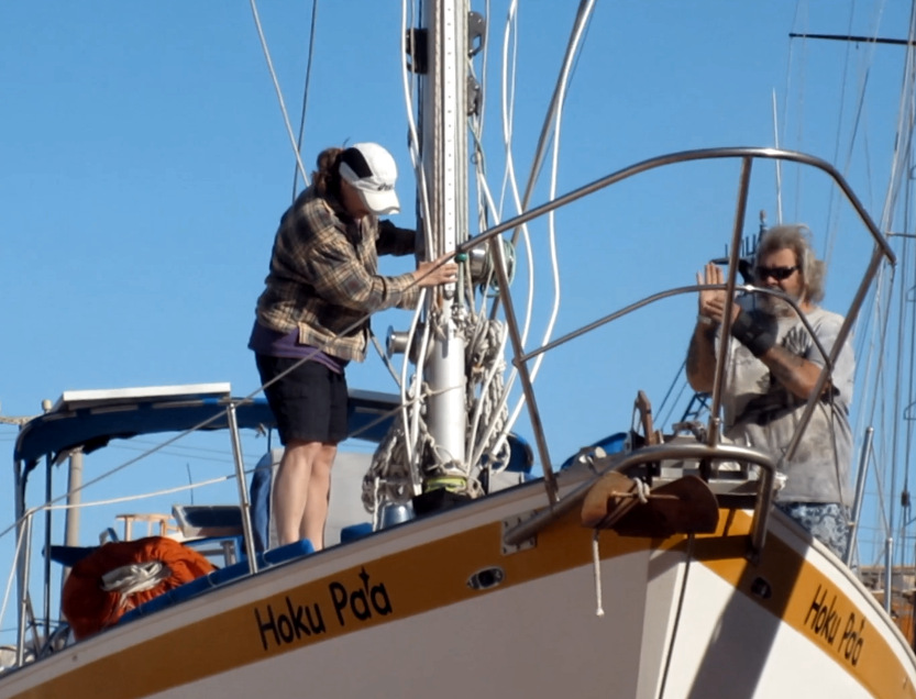 Barb and Michel guiding the mast into location from on deck
