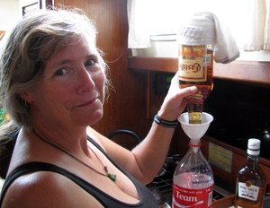 Barb funneling rum, into a plastic bottle