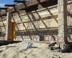 Boarded up house with skulls on front porch