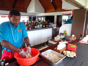 Person mixing cubes of fish with coconut cream