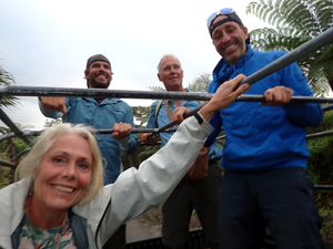 Three people standing in the back of the pickup truck and a fourth seated - all smiling